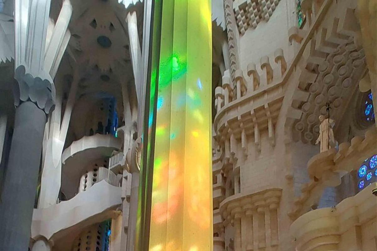 Una columna de color arcoíris en una iglesia con un edificio.