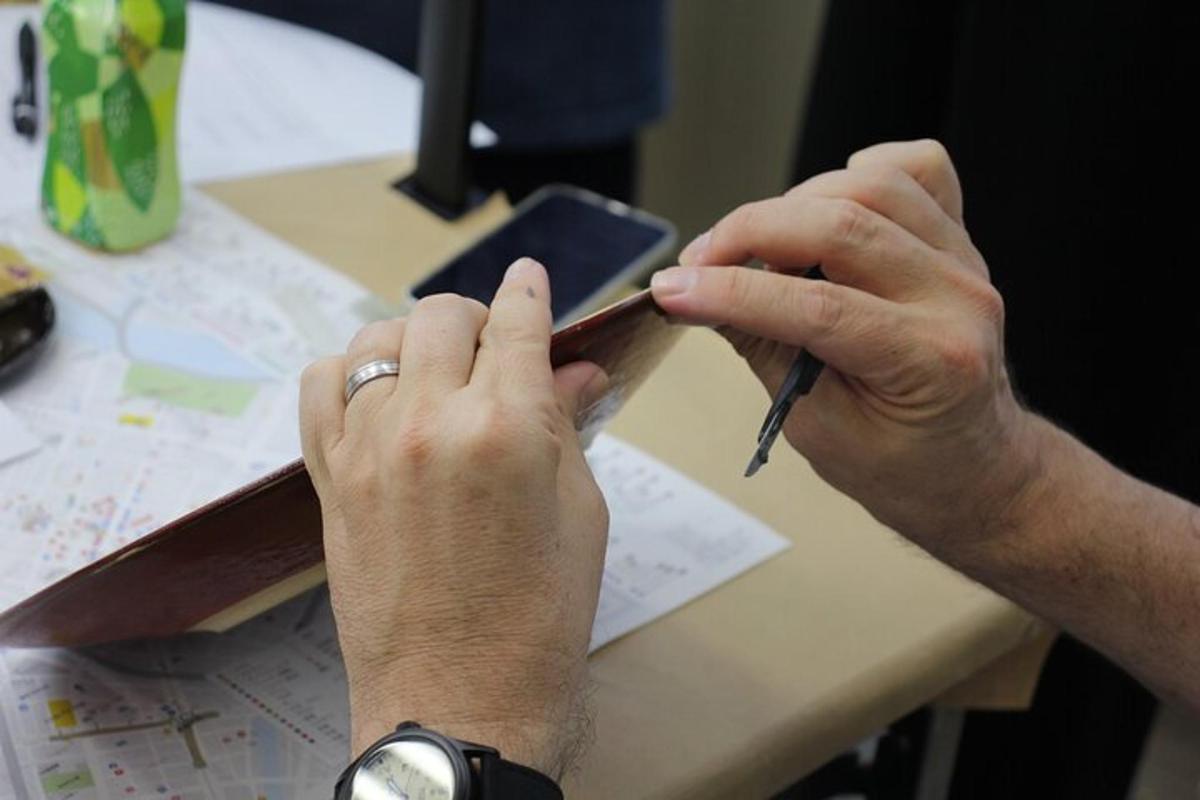osoba píšící na mobilním telefonu u stolu