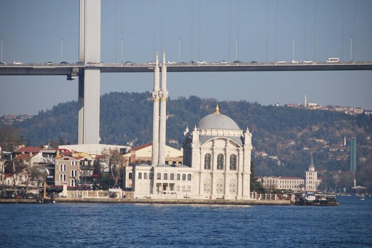 ένα μεγάλο λευκό κτίριο στο νερό δίπλα σε μια γέφυρα