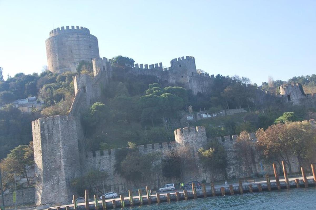 un castillo en la cima de una colina junto al agua