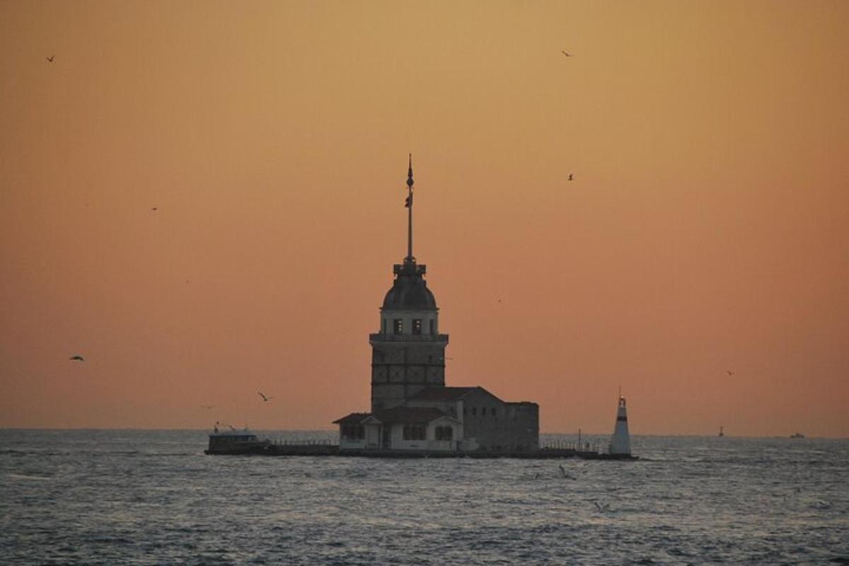 a building in the water with a lighthouse in the ocean