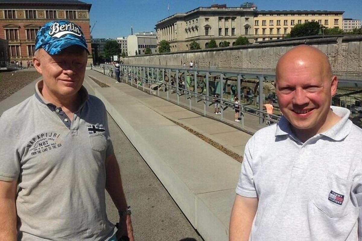two men standing next to each other on a bridge