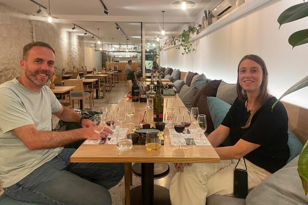 un uomo e una donna seduti a un tavolo con bicchieri di vino