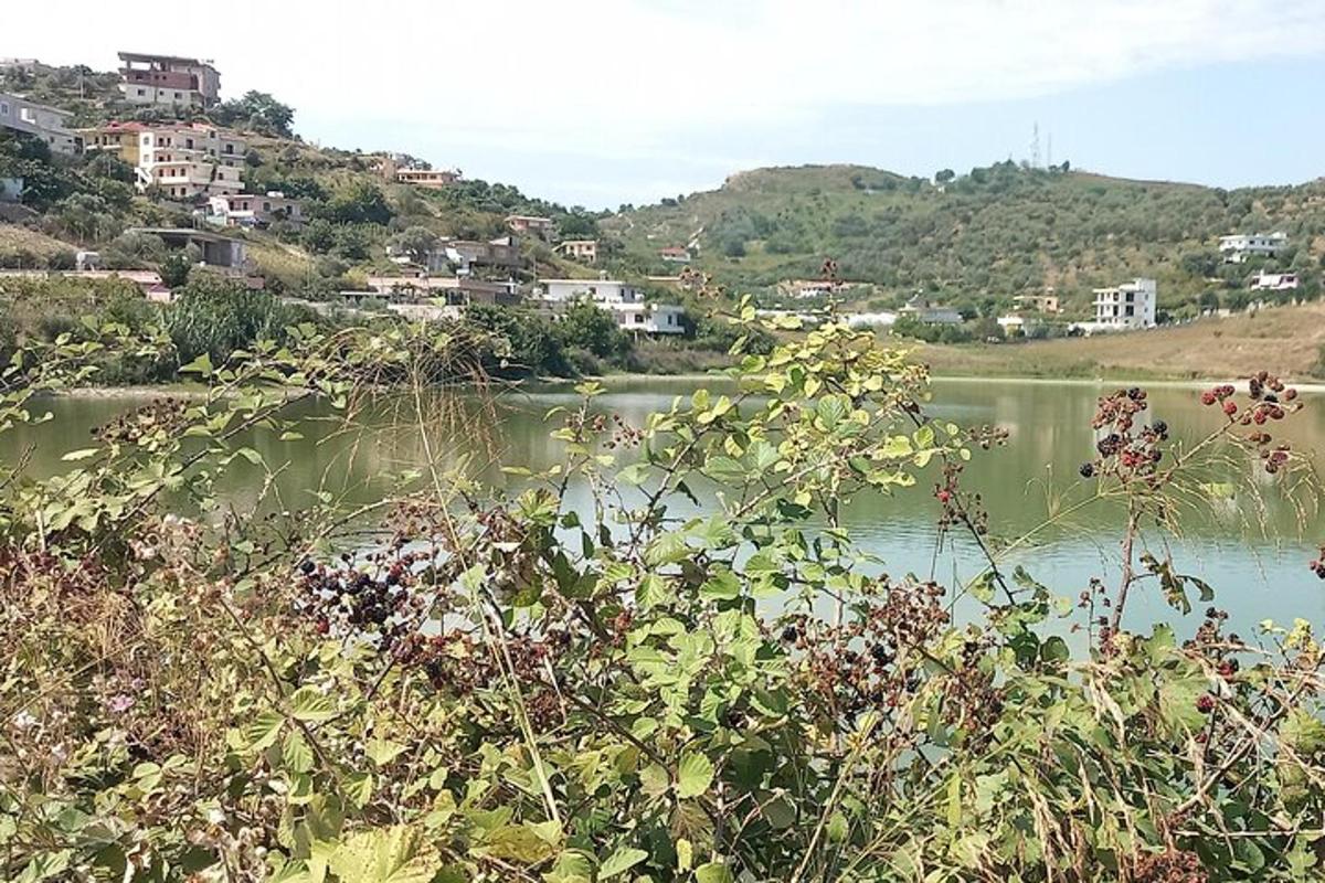 uno specchio d'acqua con una città sullo sfondo