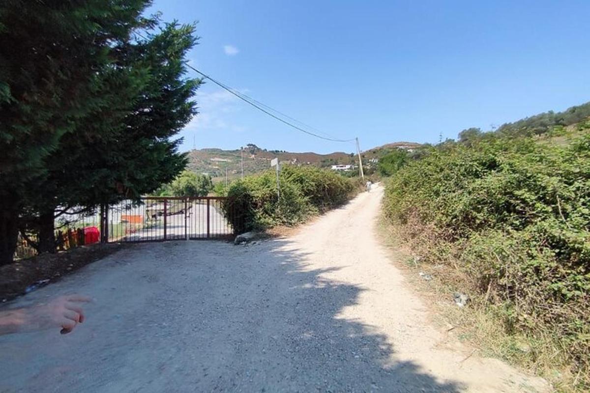 una strada sterrata con un cancello sul lato