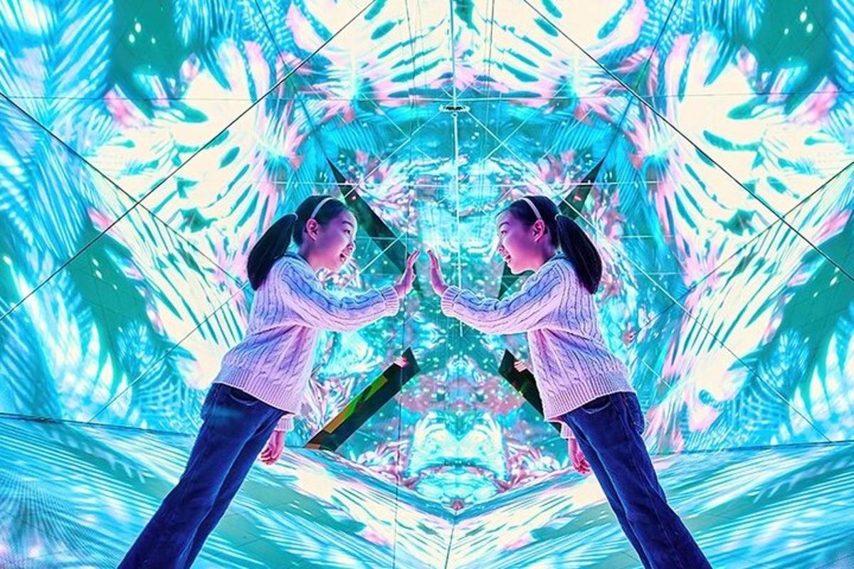 two girls are standing in front of a kaleidoscope