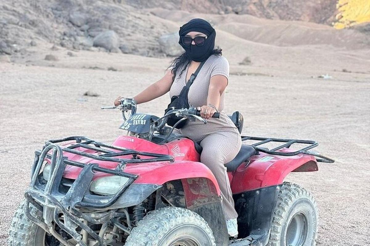 a woman is sitting on a four wheeler in the desert