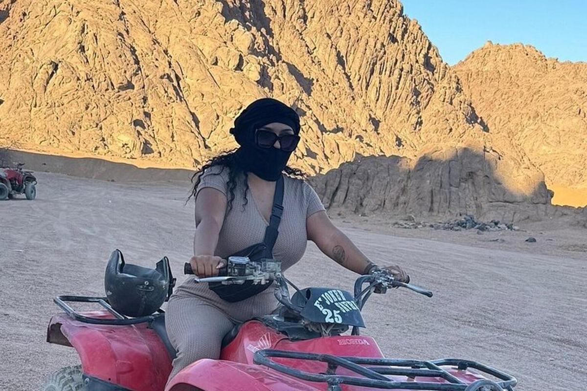 a woman riding a red motorcycle in the desert