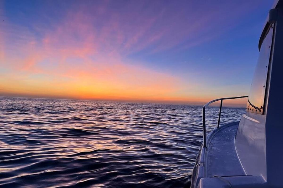 a boat in the ocean with a sunset