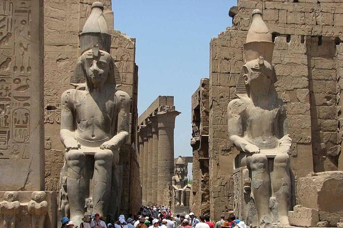 Un grupo de personas de pie frente a dos estatuas.
