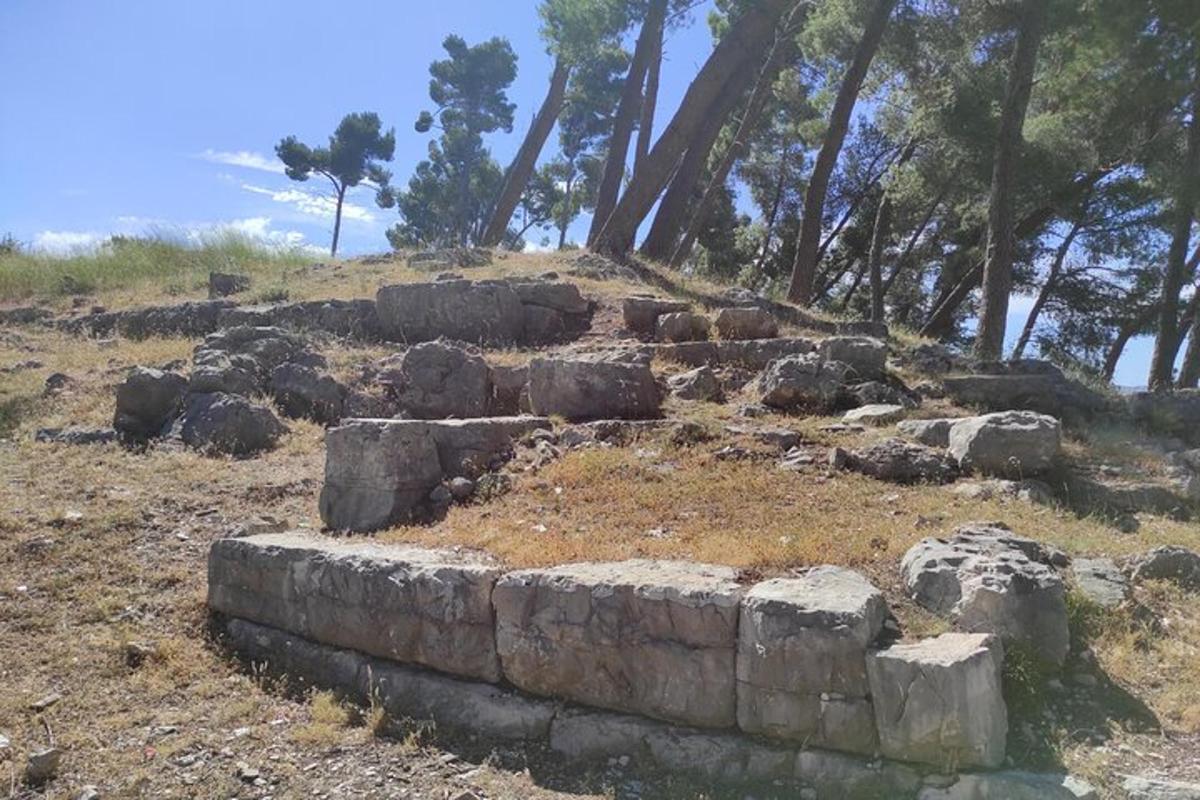 un mucchio di rocce in cima a una collina con alberi