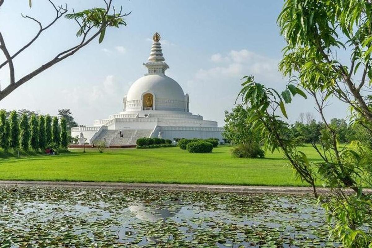 a temple with a large white building and a pond