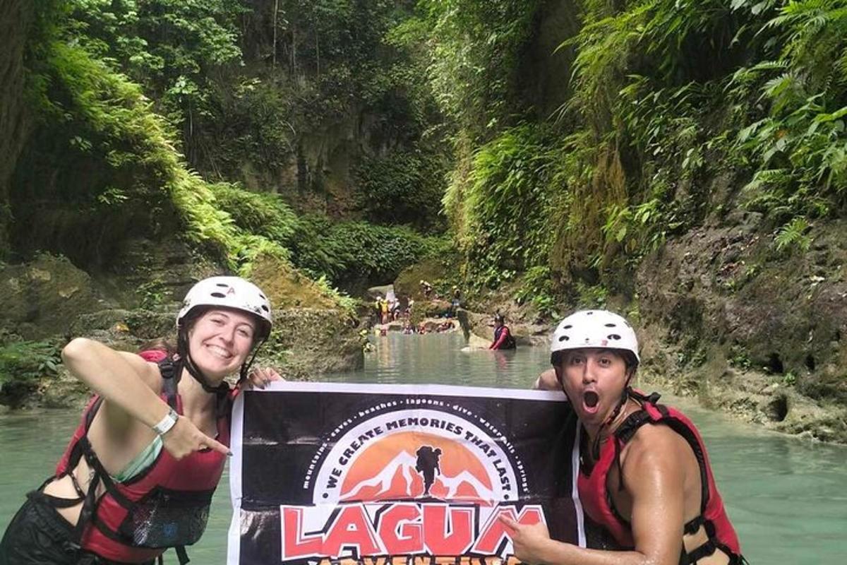 dua lelaki bertopi keledar memegang papan tanda di sungai