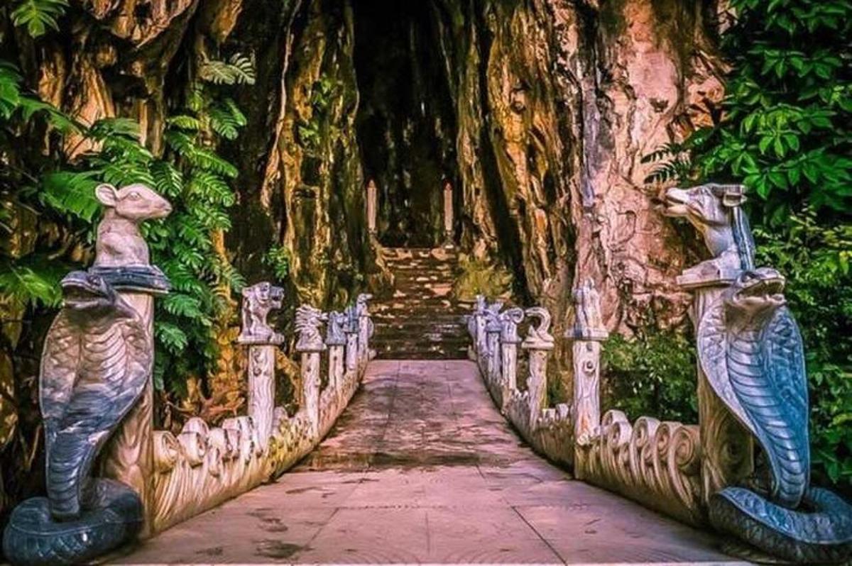 Un puente con estatuas frente a un árbol.