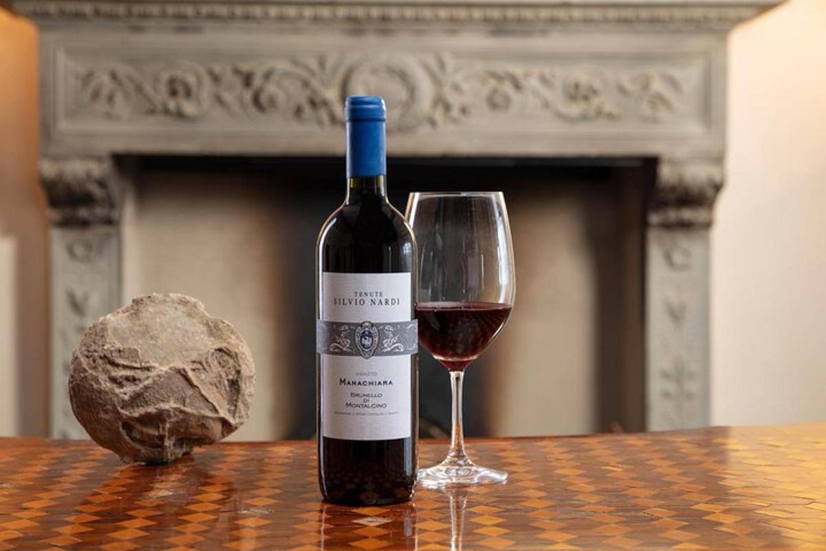 uma garrafa de vinho tinto e uma taça sobre uma mesa