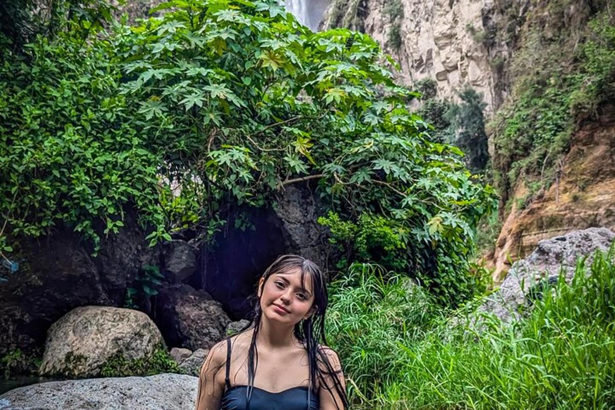 una donna è in piedi davanti a una cascata
