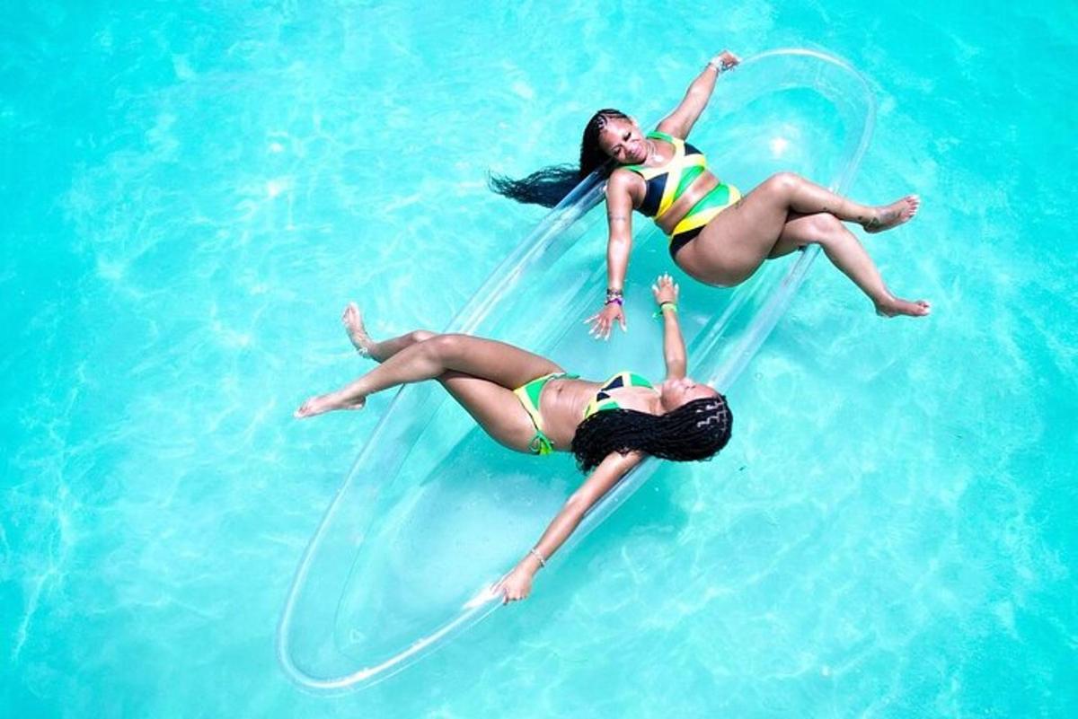 zwei Mädchen im Wasser spielen mit einem Schlauch
