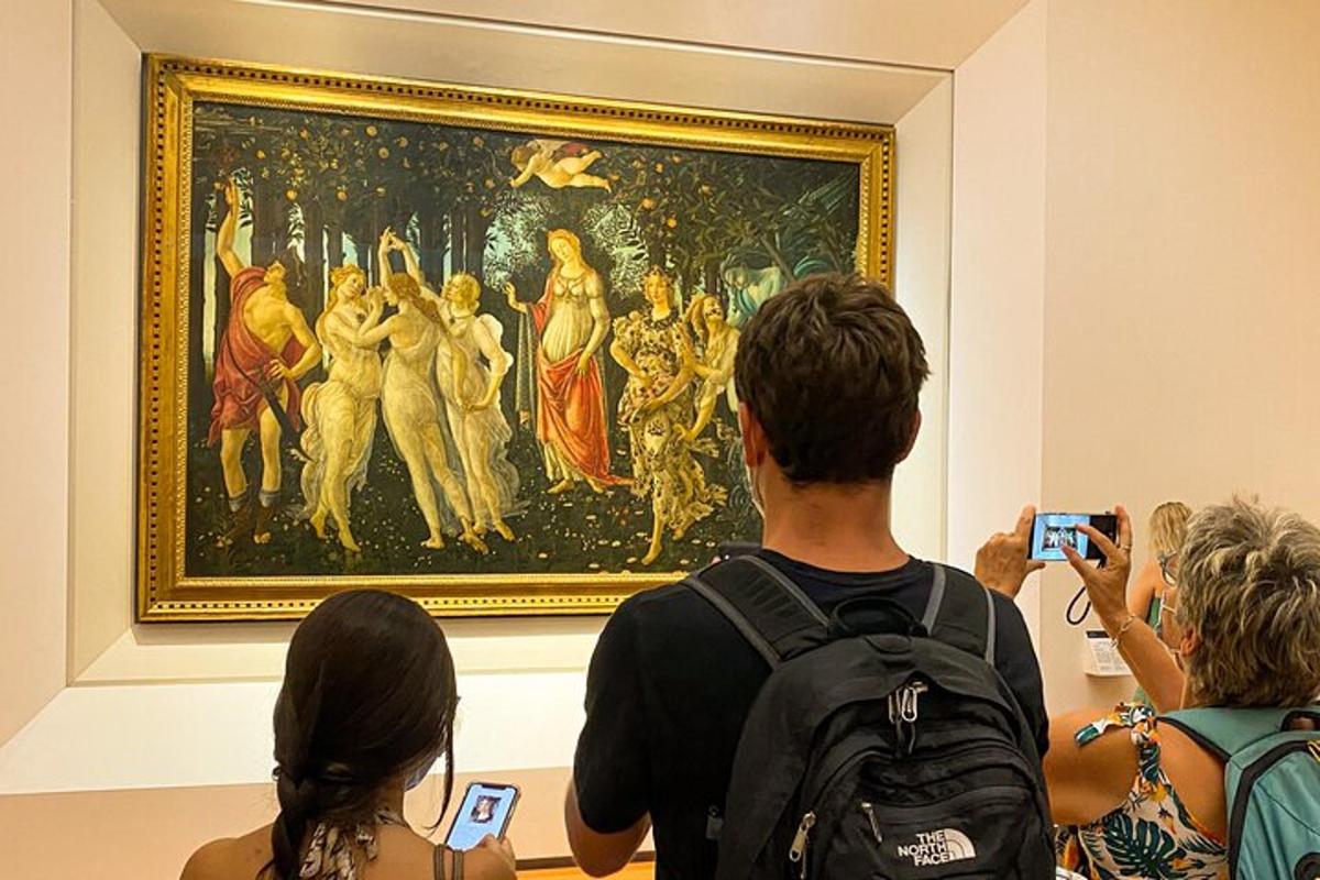 people taking pictures of a painting in a museum