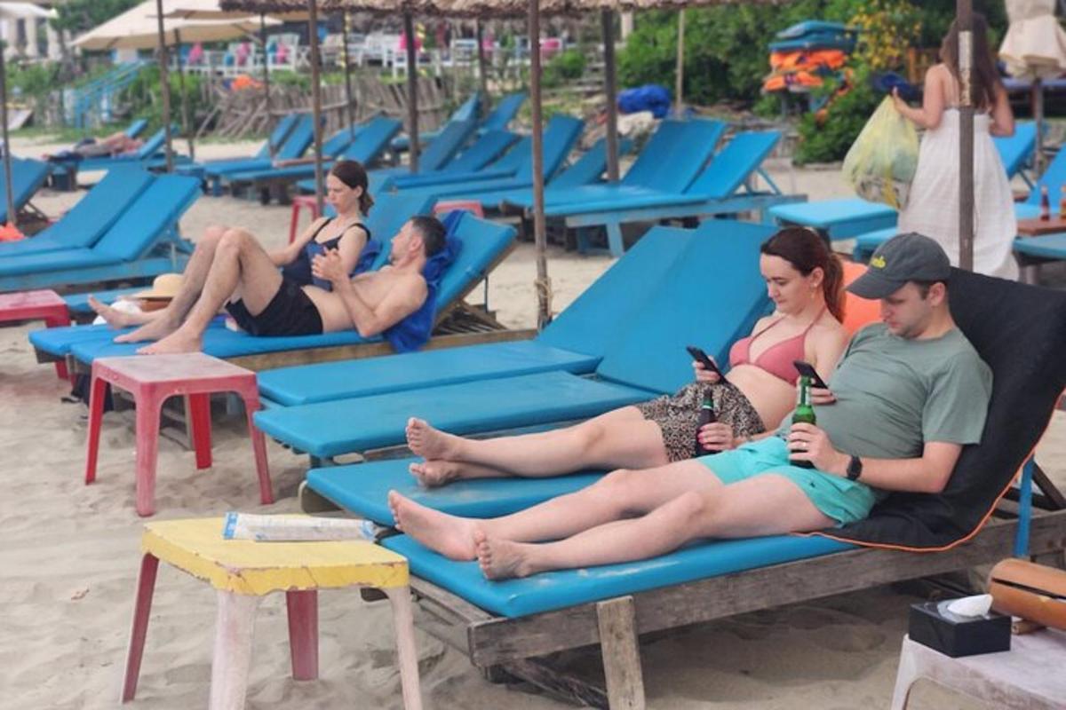 skupina lidí sedících na židlích na pláži