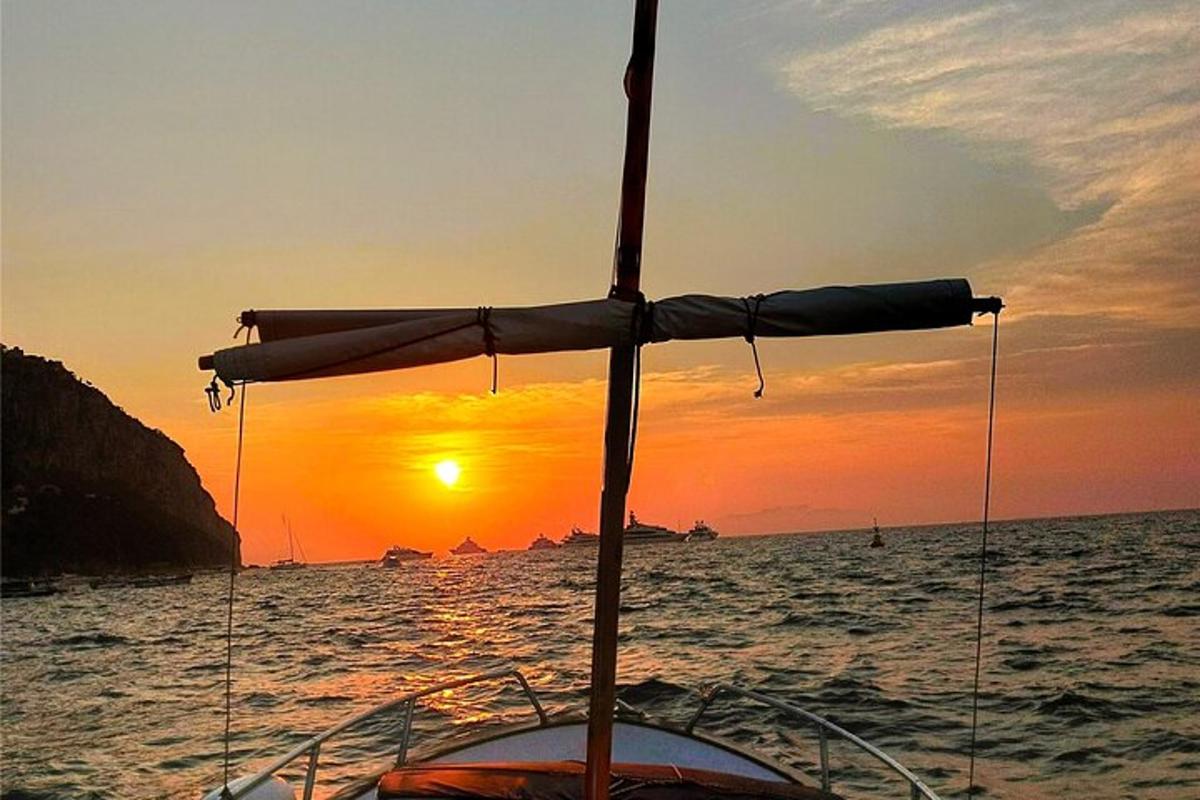 Loď s deštníkem na oceánu při západu slunce