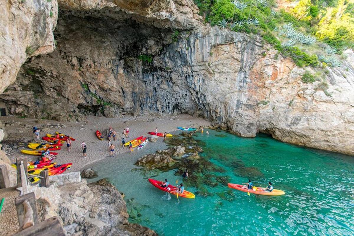 un gruppo di persone su una spiaggia con barche in acqua
