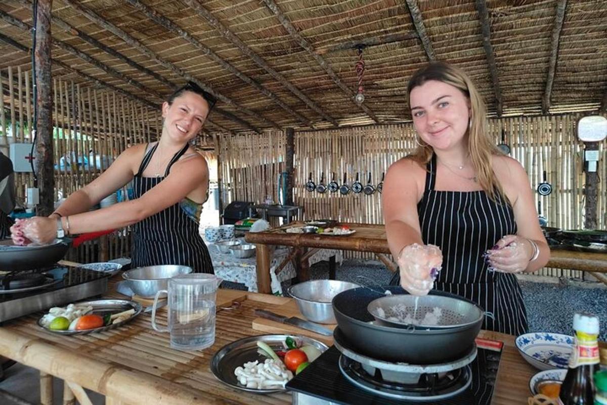 dues dones dempeus a la cuina preparant menjar