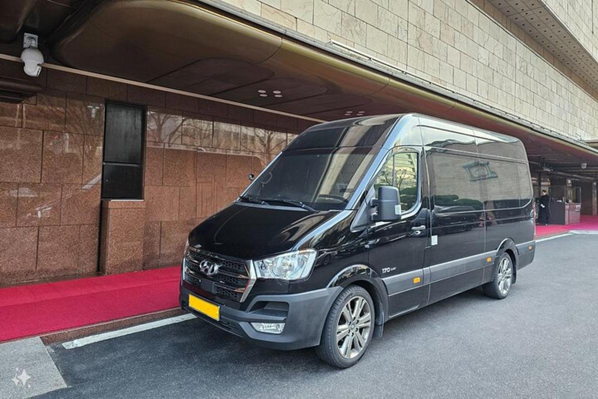 sebuah mobil van hitam diparkir di depan sebuah gedung