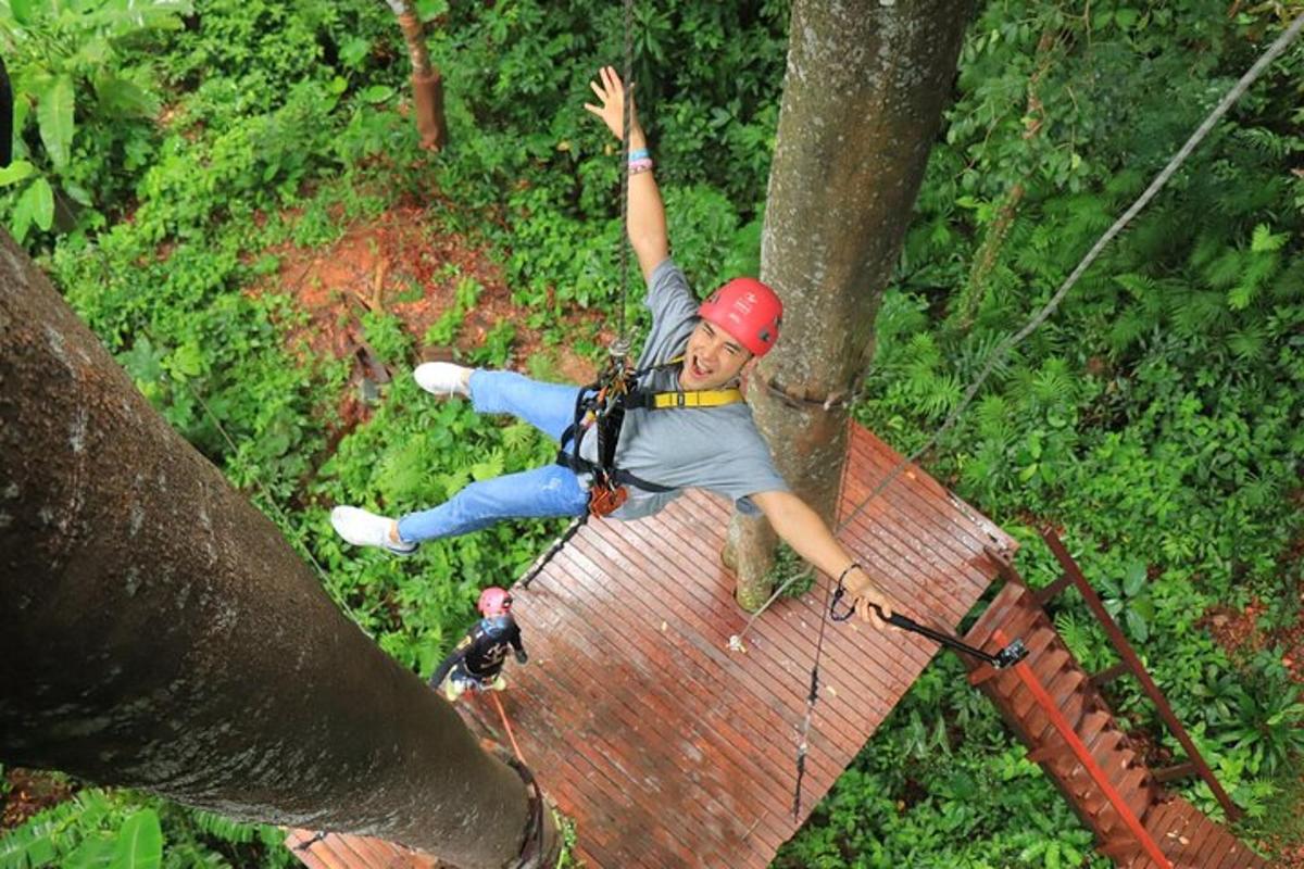 un home en una tirolina a la selva