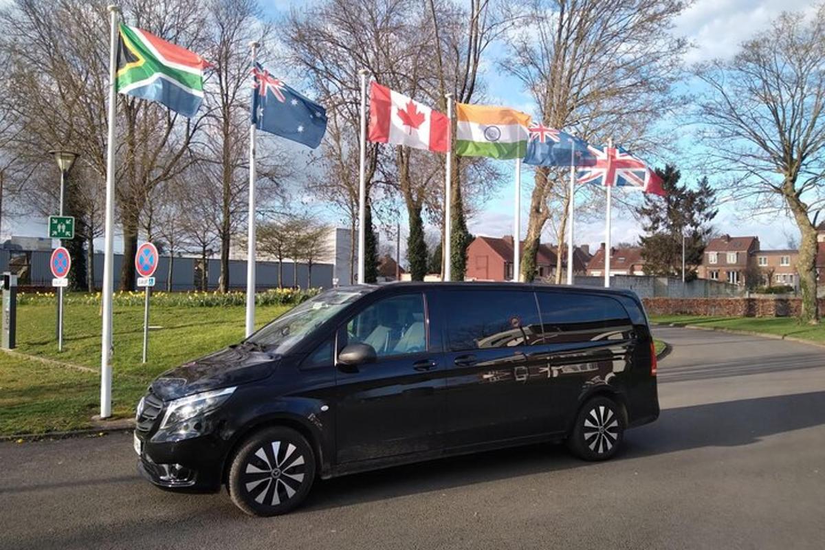 a black car is parked in front of flags
