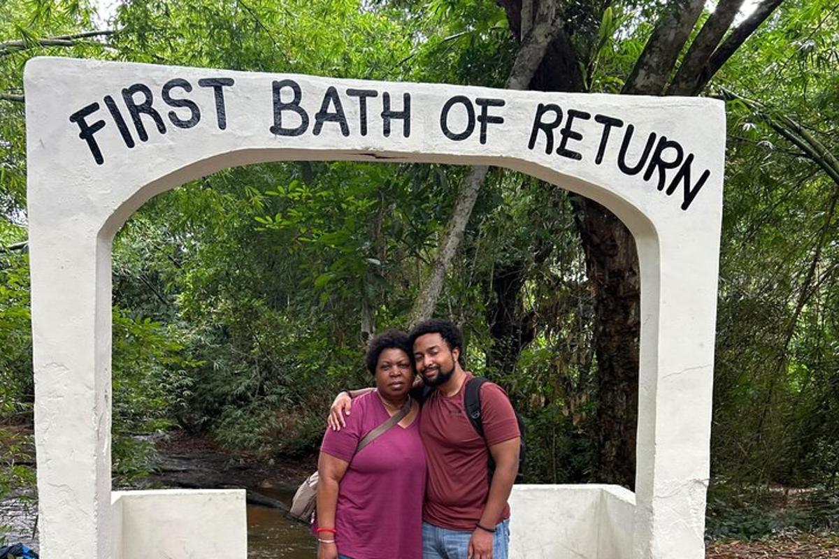 Dos hombres de pie bajo un cartel que señala el primer camino de retorno.
