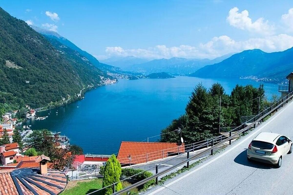 a car driving down a road next to a lake