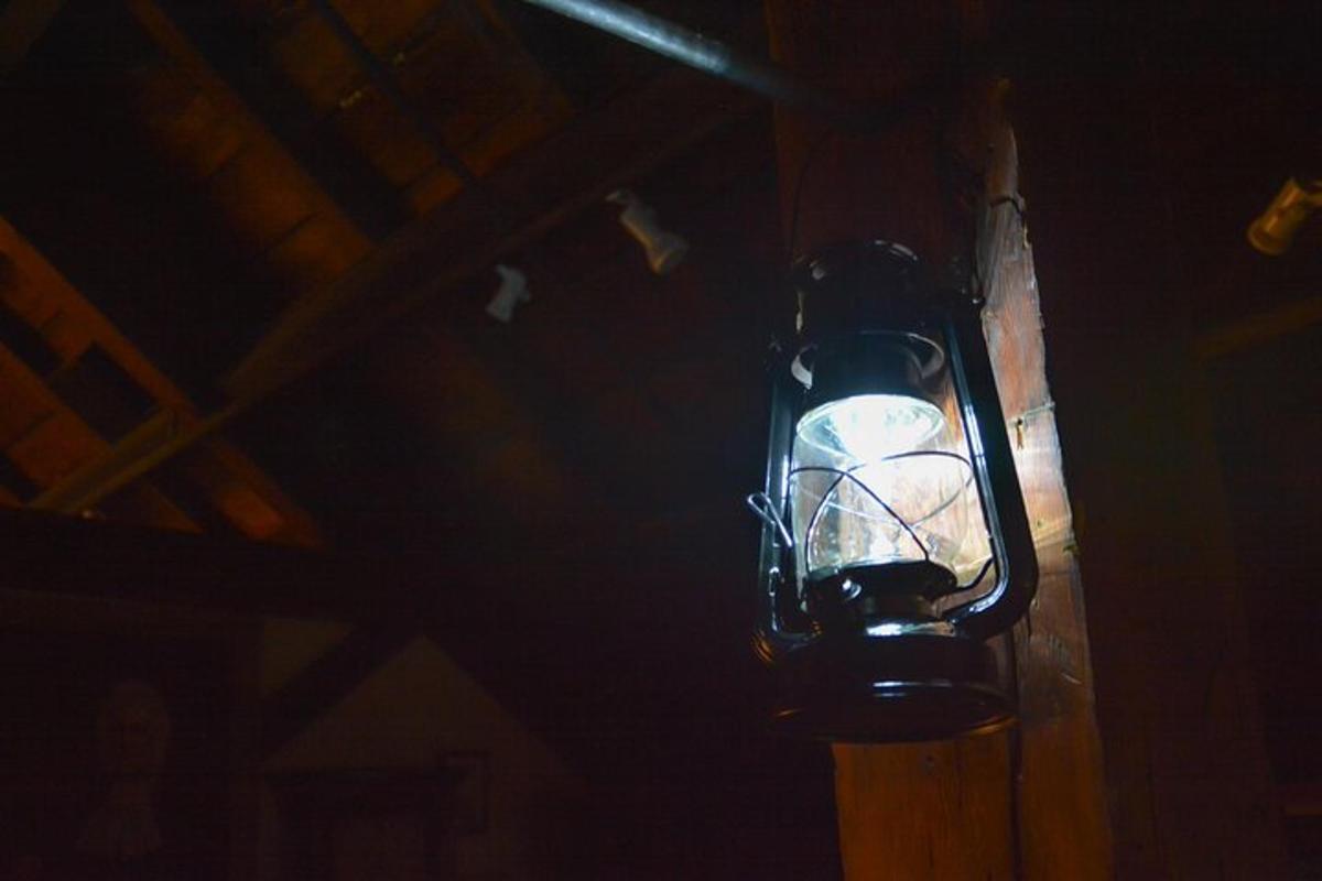 una luce attaccata a un palo di legno nell'oscurità