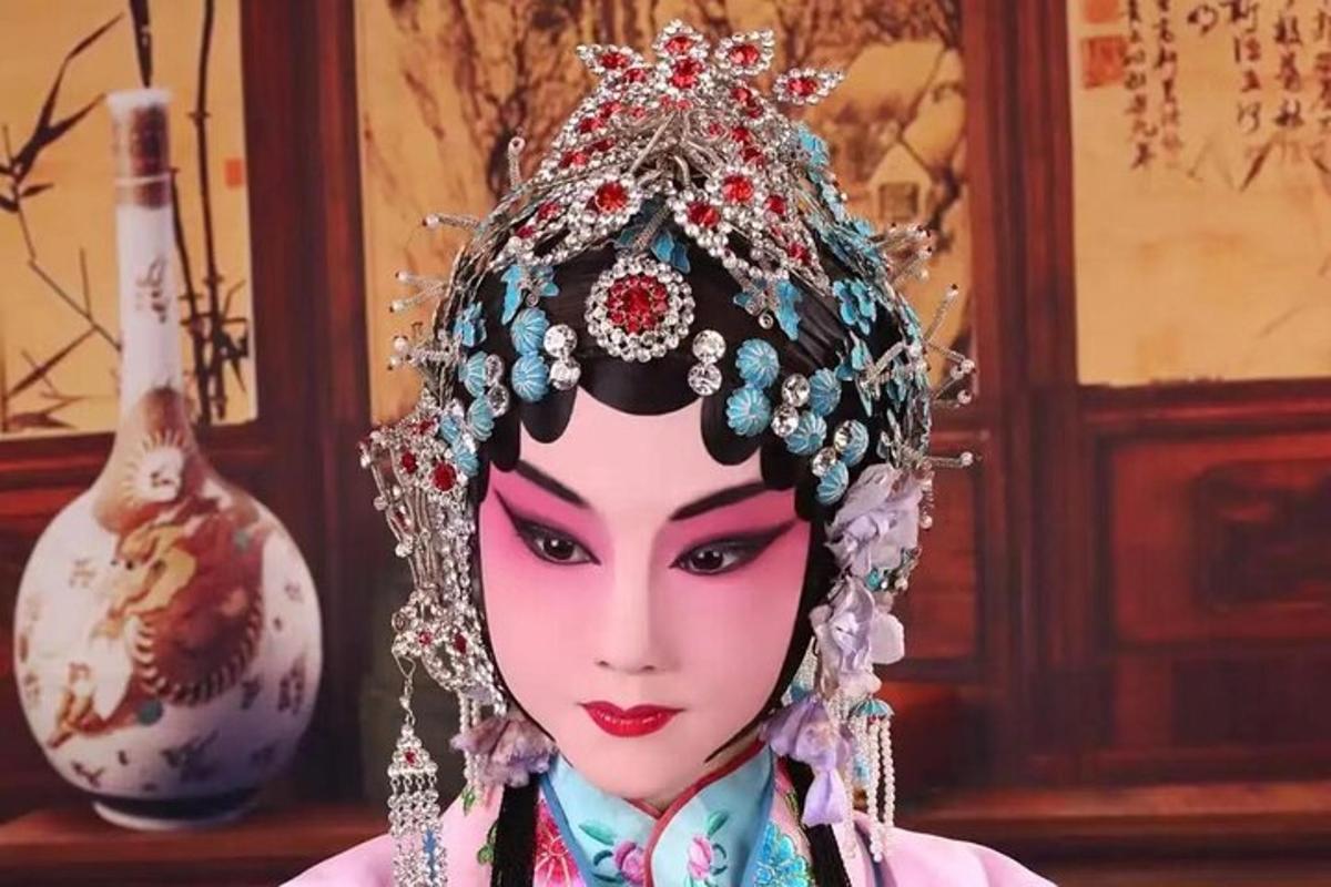 a doll with a tiara on its head next to a vase