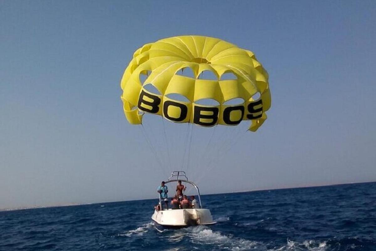 Un gran paracaídas amarillo volando sobre el océano.