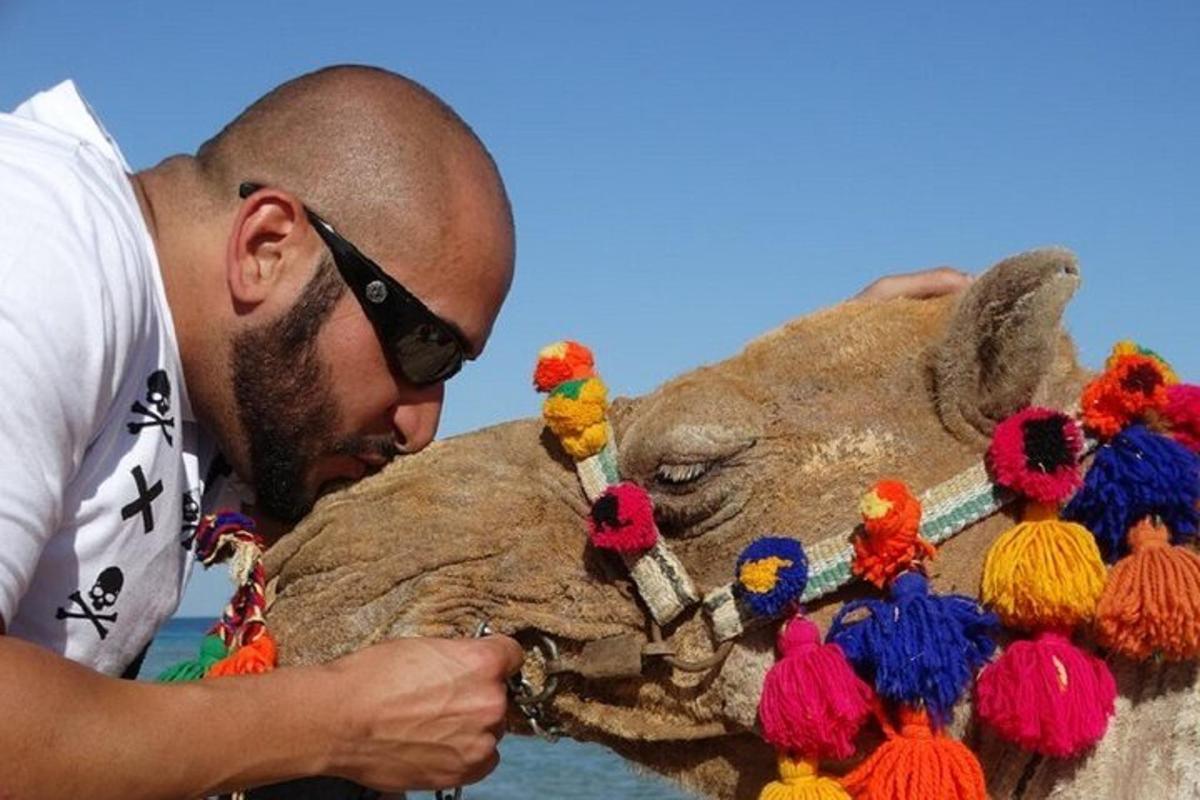 Un hombre de pie junto a un animal de peluche