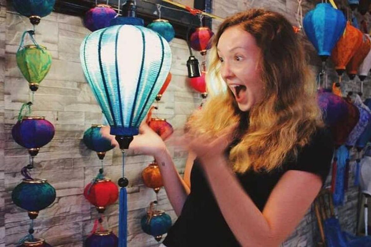 a woman is holding a blue and white balloon