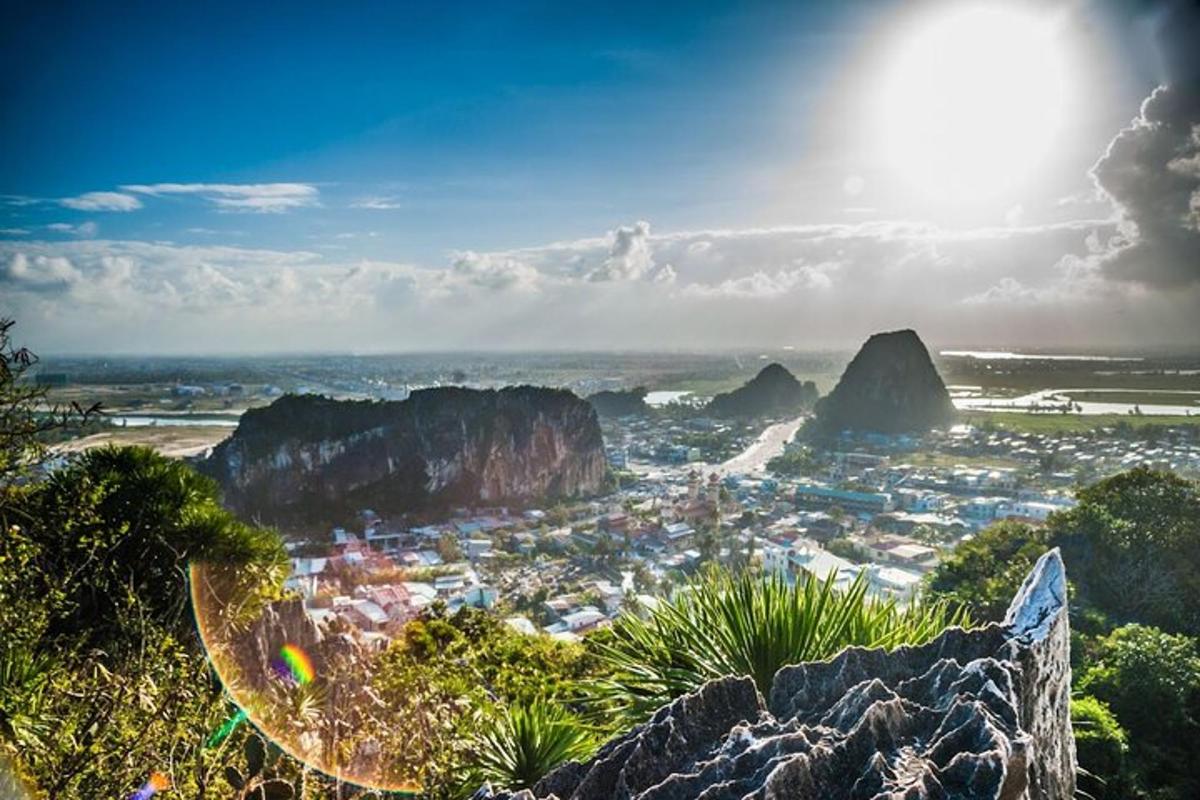 una vista di una città con montagne e sole