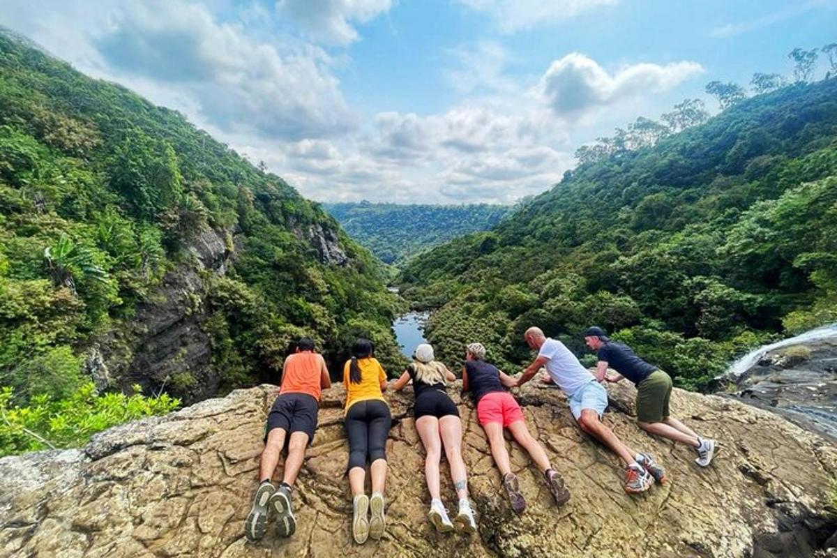 a group of people sitting on a rock overlooking a river