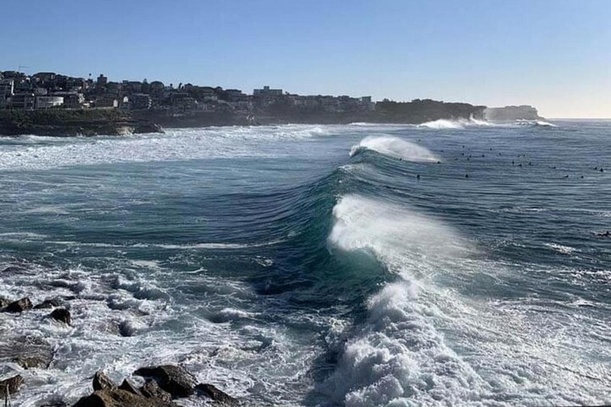 un val în ocean cu un oraș în fundal