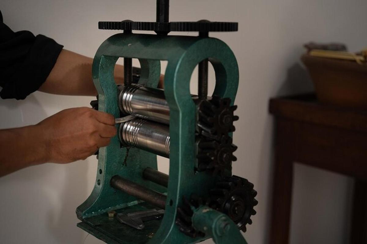 Una persona está usando una máquina de coser verde.