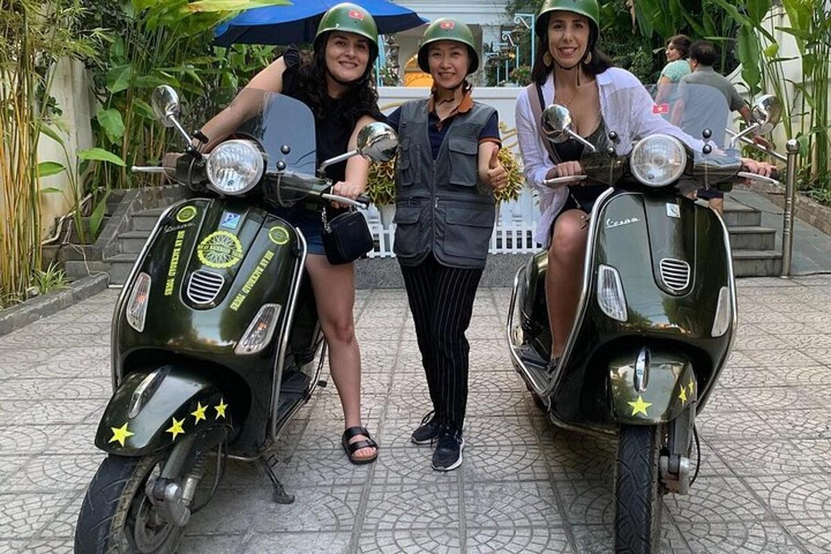 Tres mujeres están de pie junto a sus scooters.