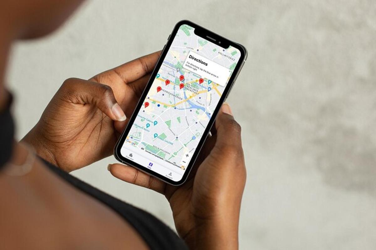 osoba držící mobilní telefon s mapou na něm
