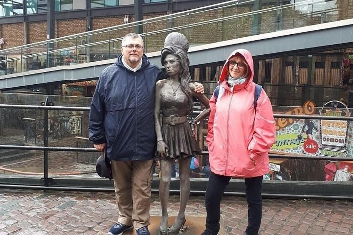 um homem e uma mulher em pé ao lado de uma estátua