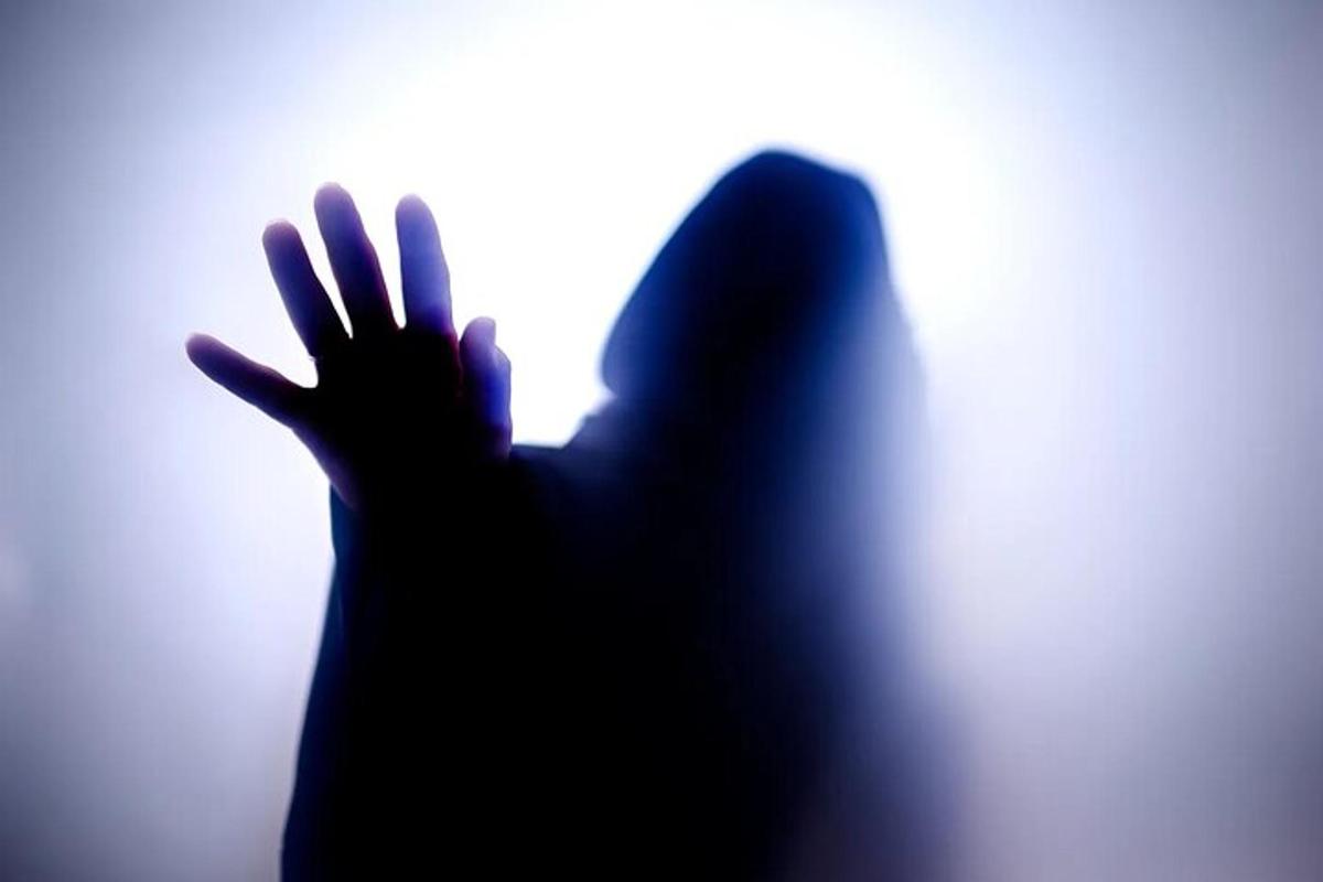 eine Silhouette einer Person, die ihre Hand gegen ein Fenster drückt