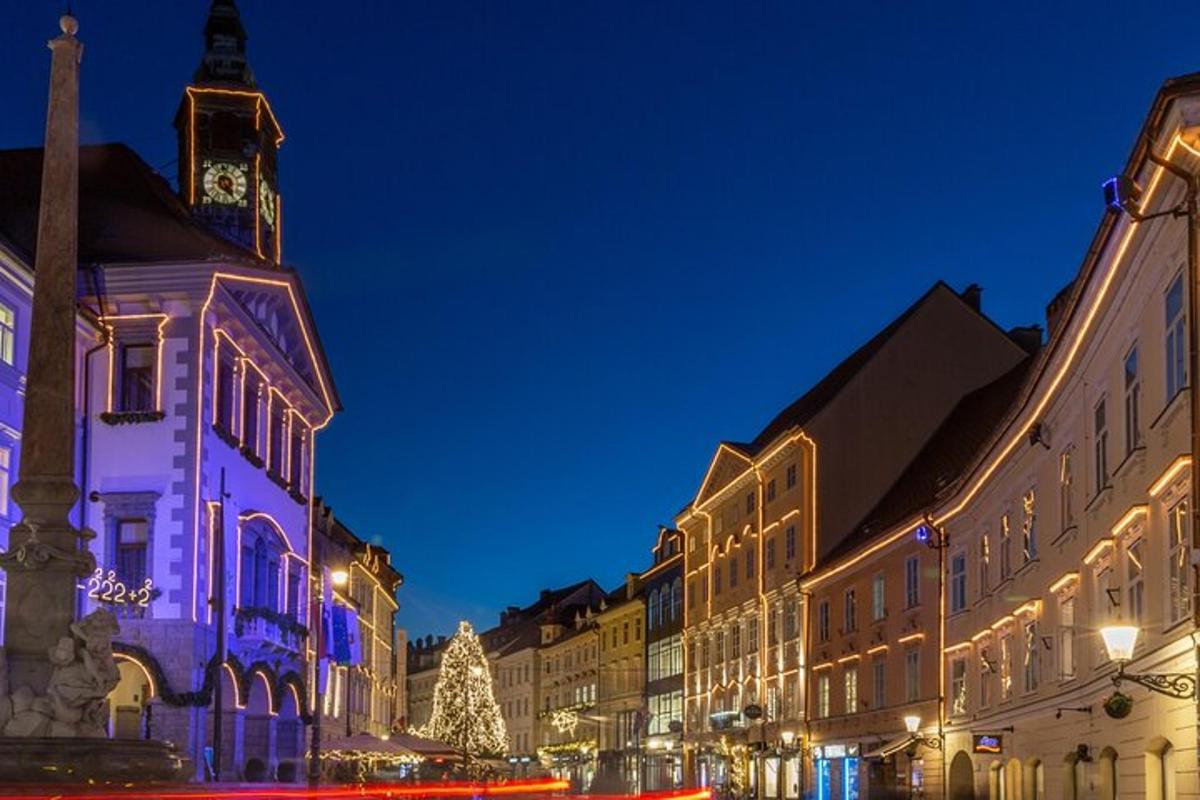eine beleuchtete Stadtstraße bei Nacht mit einem Weihnachtsbaum