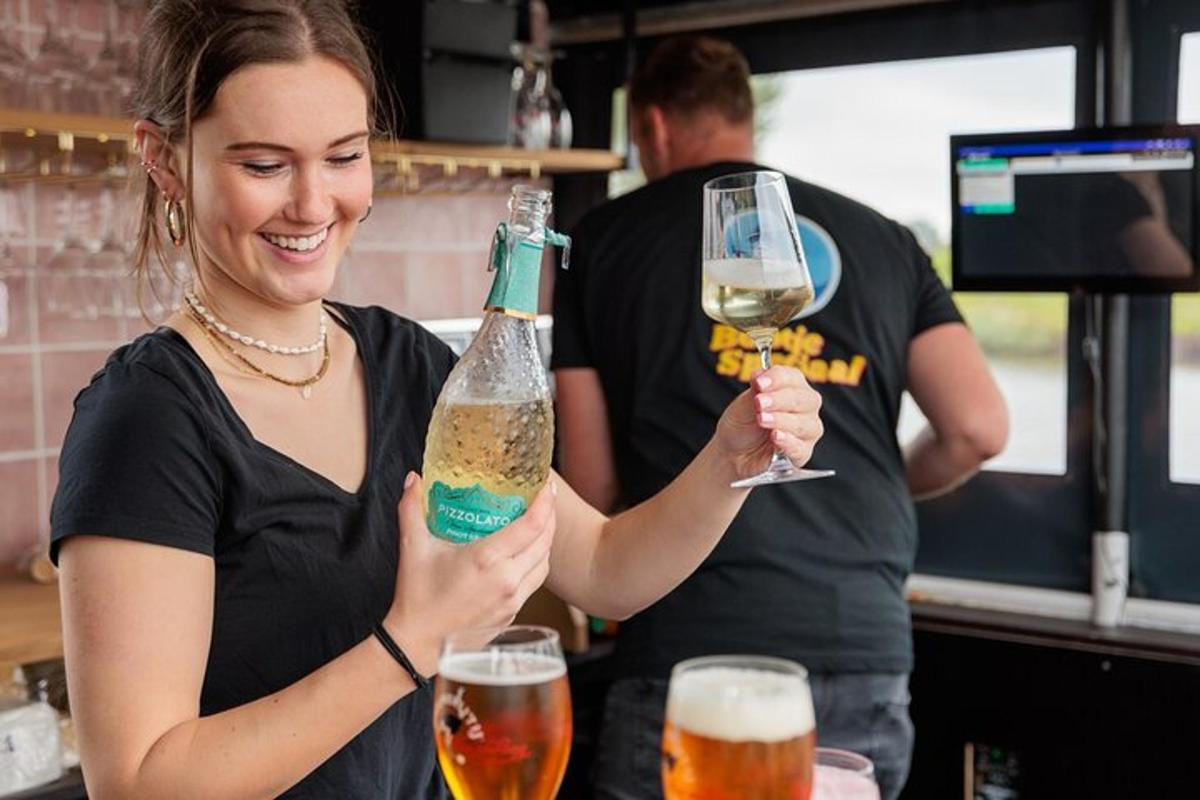 una donna che tiene in mano una bottiglia e due bicchieri di birra