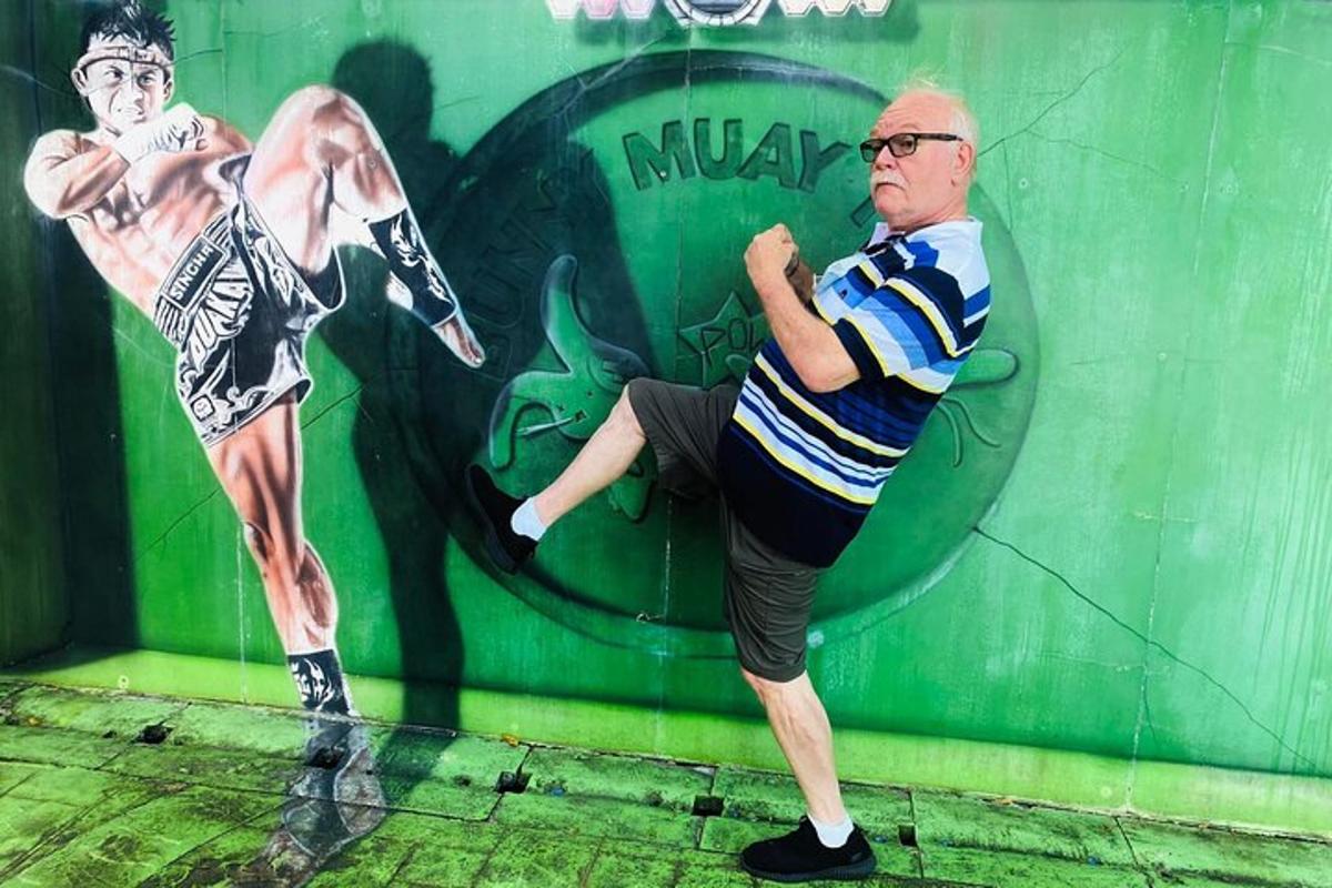 muž stojící před zdí s obrazem