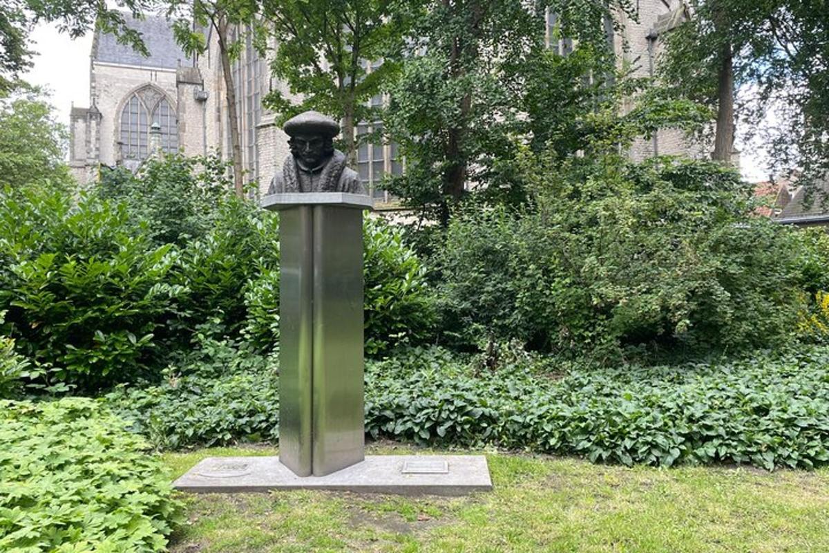 una estàtua d'un bust d'un home en un jardí