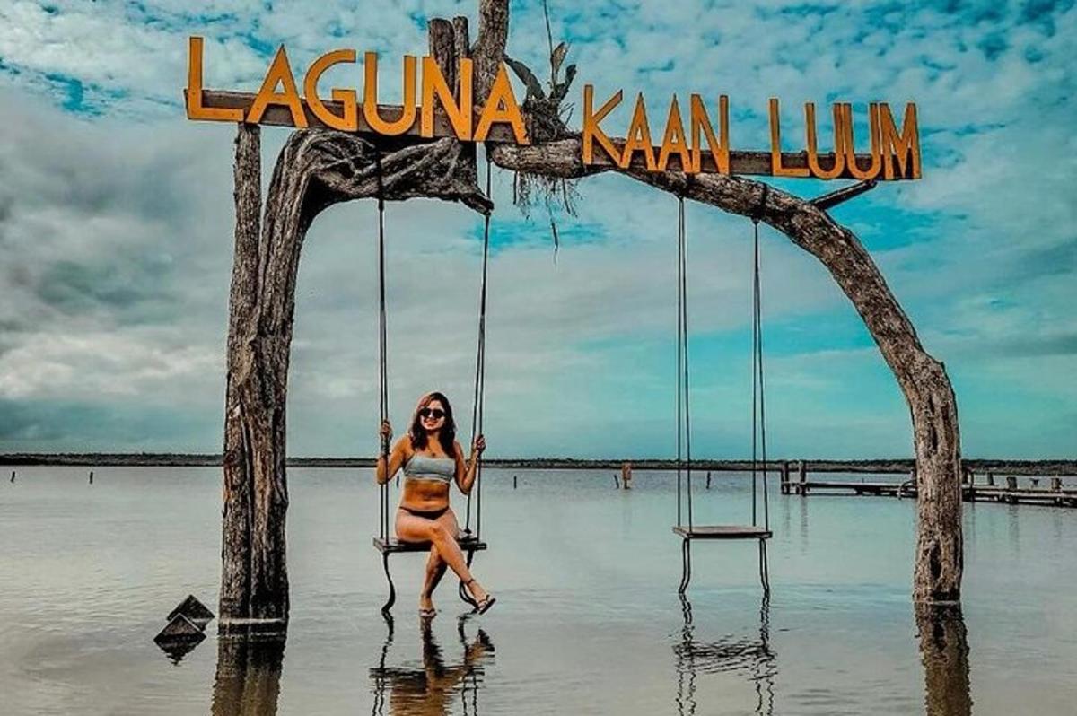 ženska v bikiniju sedi na gugalnici na plaži