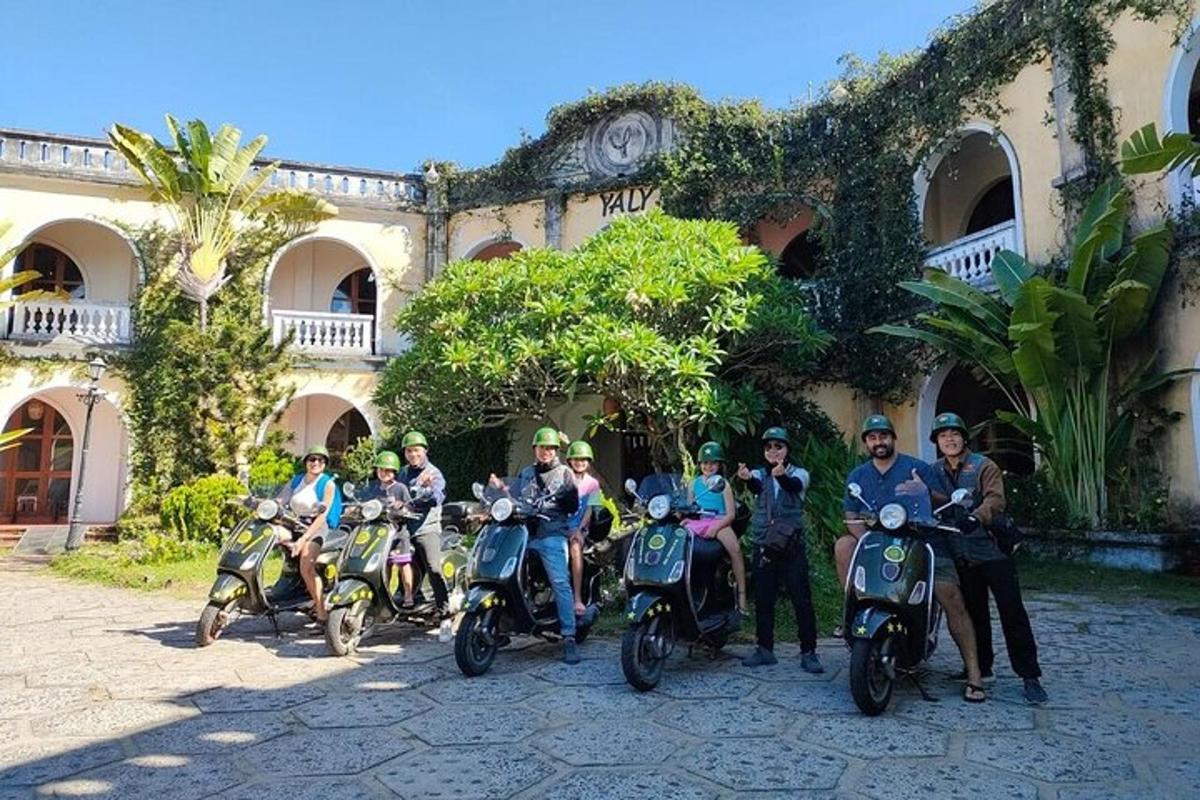 Un grupo de personas en scooters estacionados frente a un edificio.